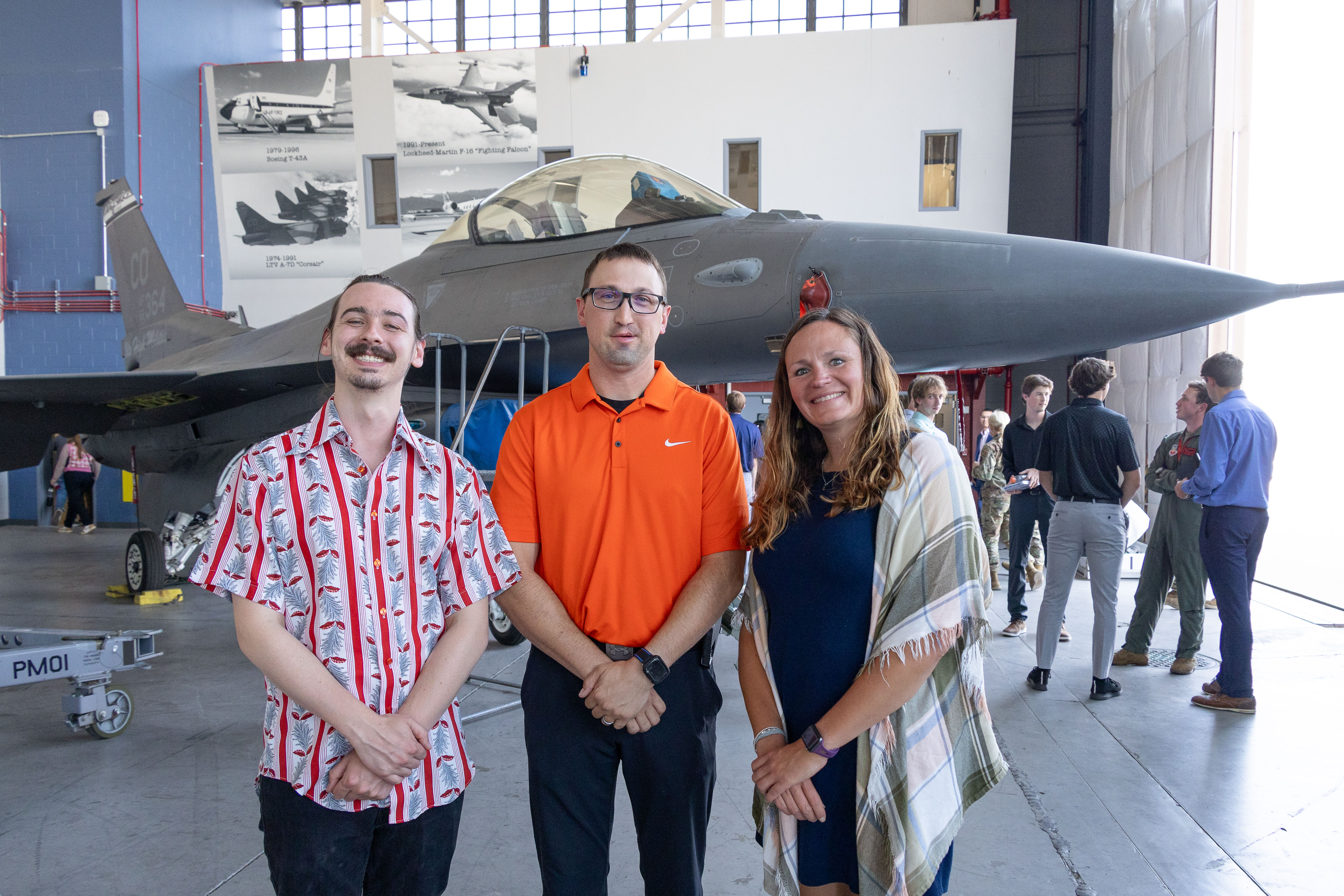 Three teachers smile in front of an F16 at Buckley Space Force Base. 