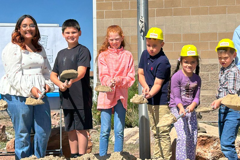 Kids playing with shovels during the groundbreaking of a BEST school in Hanover.