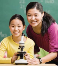 Photo of teacher and student behind a microscope
