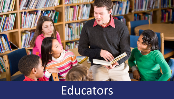 Teacher reading a book to students in library