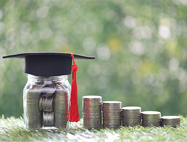 Jar of coins with graduation cap