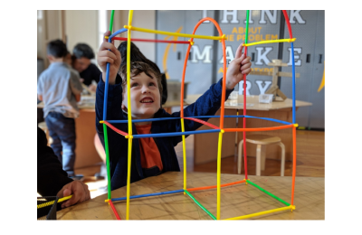 young child building a tower using connector toys