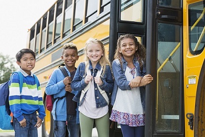 group of children waiting outside the school bus